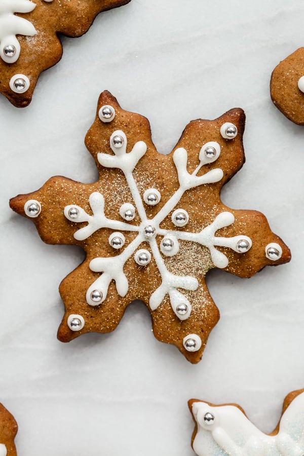 a snowflake gingerbread cookie topped with icing and glitter