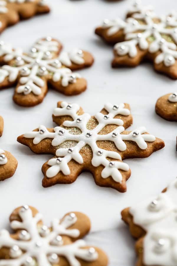 snowflake gingerbread cookies with royal icing on a marble board