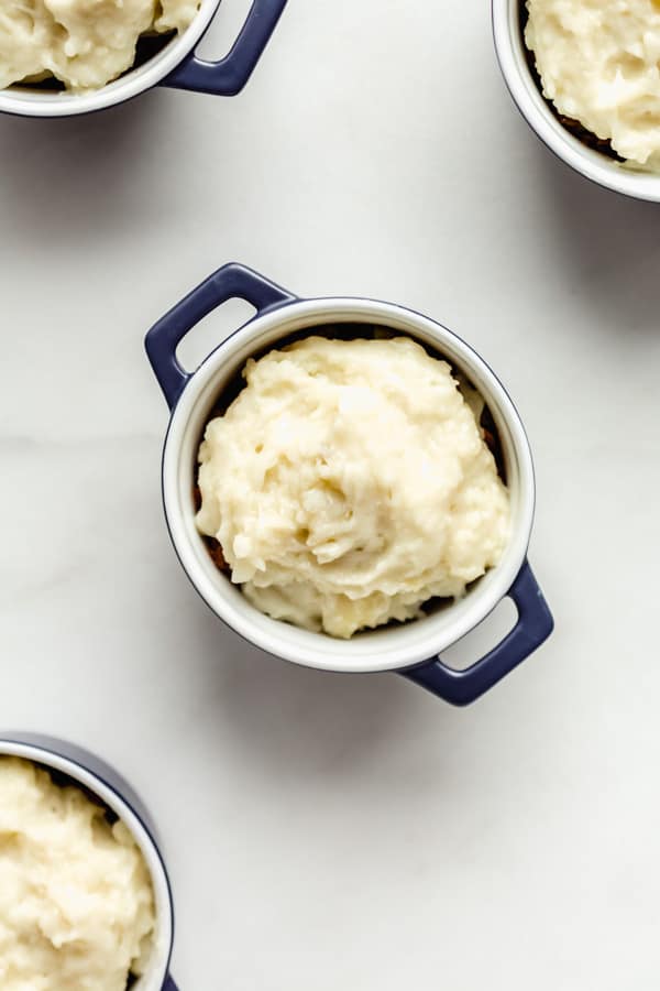 blue ramekins with lentils topped with mashed potatoes