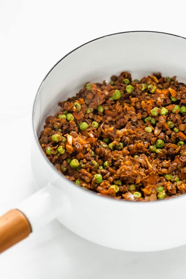 lentils, peas and vegetables in a white pot