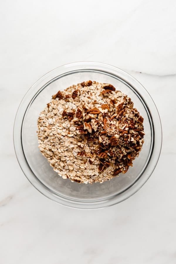 oats and pecans in a clear mixing bowl