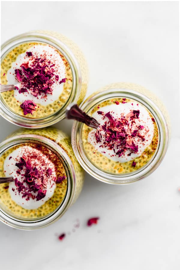 a top down view of golden milk chia pudding topped with yogurt and rose petals