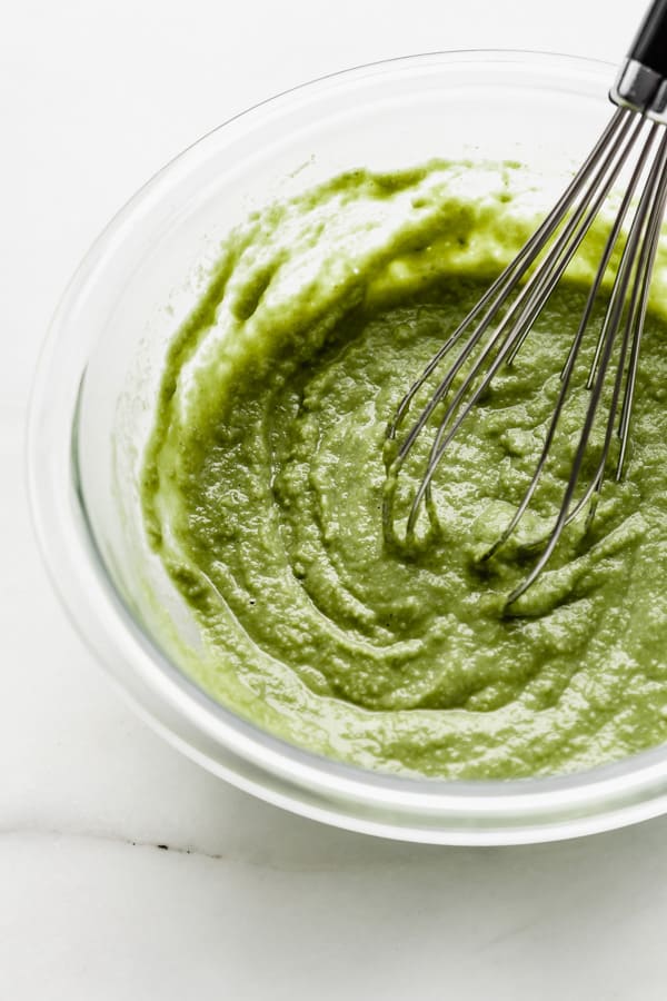 matcha pancake batter in a mixing bowl with a whisk