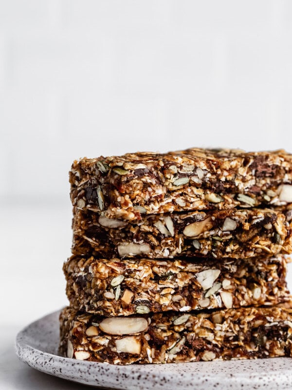 a stack of four superfood granola bars on a white ceramic plate