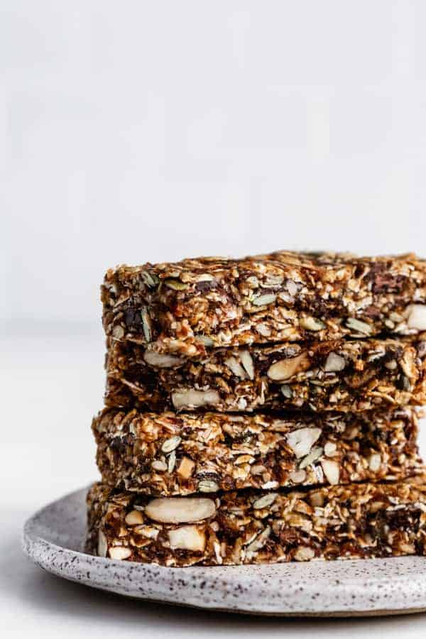 a stack of four superfood granola bars on a white ceramic plate