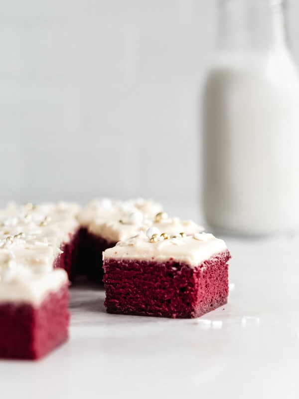 Red velvet brownies in a marble board with a jar of milk in the background