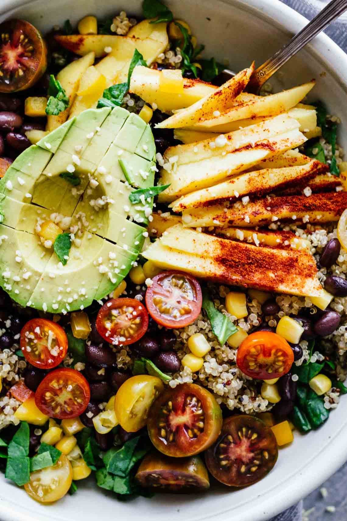 A chilli mango bowl with a half an avocado on top