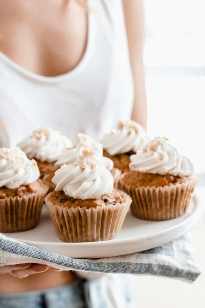someone holding a plate of cupcakes
