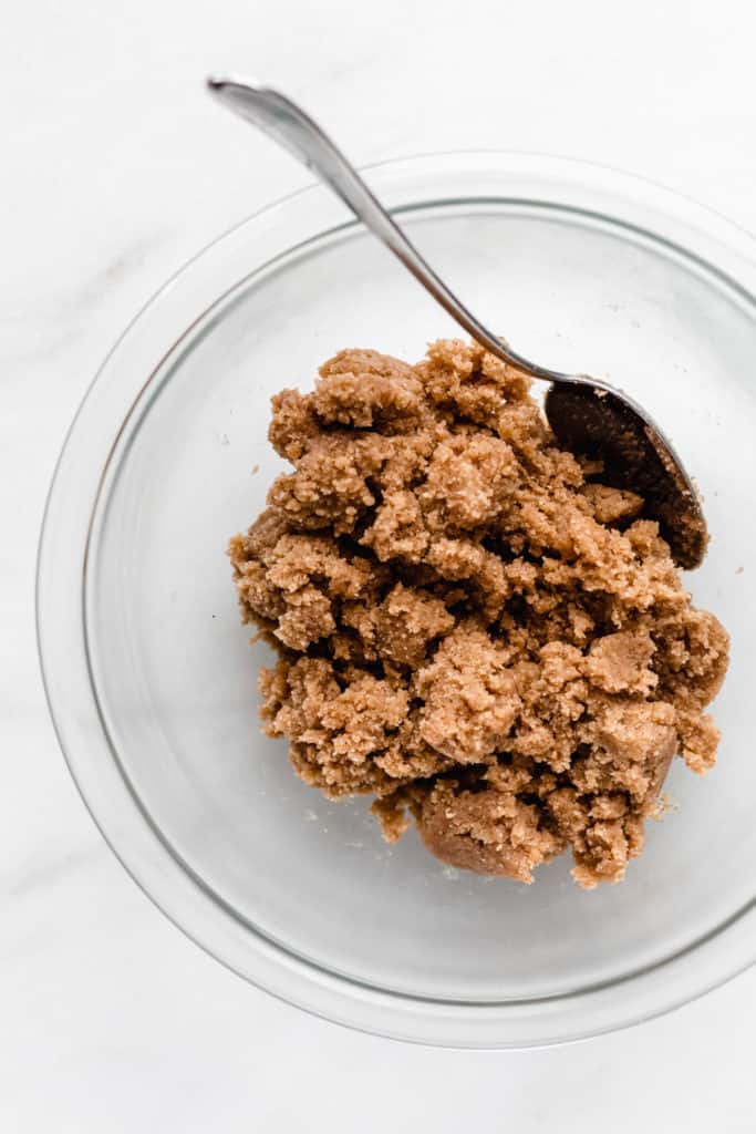 almond flour cookie dough in a clear mixing bowl with a spoon