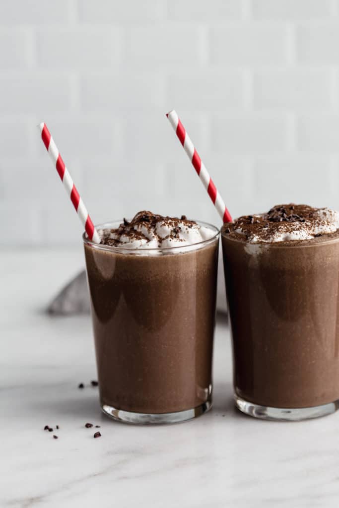 two glasses of frozen hot chocolate with red straws in them