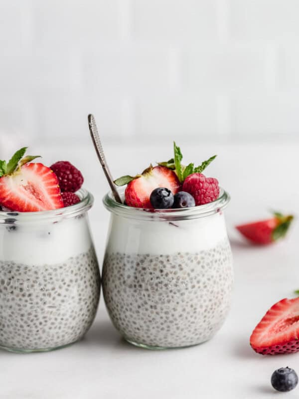 a cup of chia pudding with berries and a spoon in it