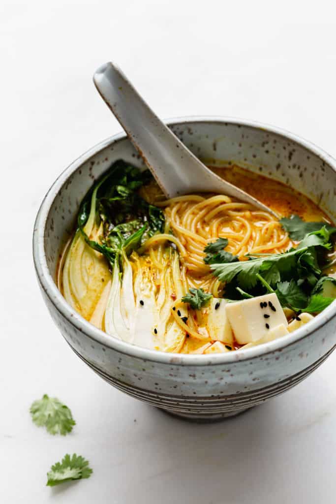 a blue speckled bowl with laksa in it