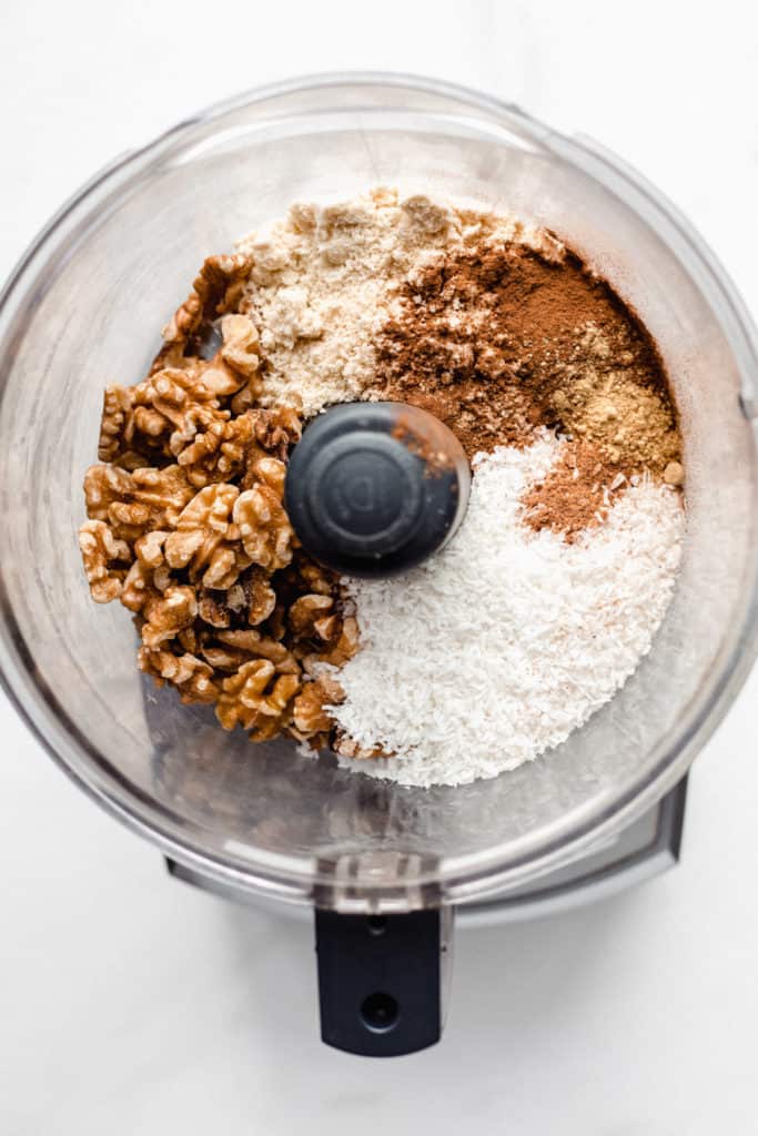 a food processor with shredded coconut and nuts in it
