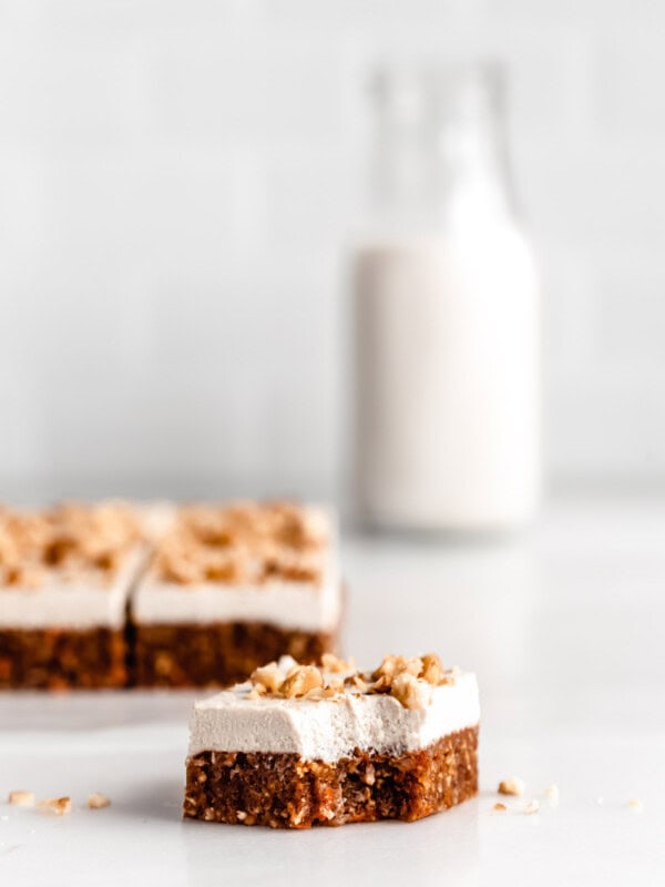 a square of raw carrot cake with a bite taken out of it