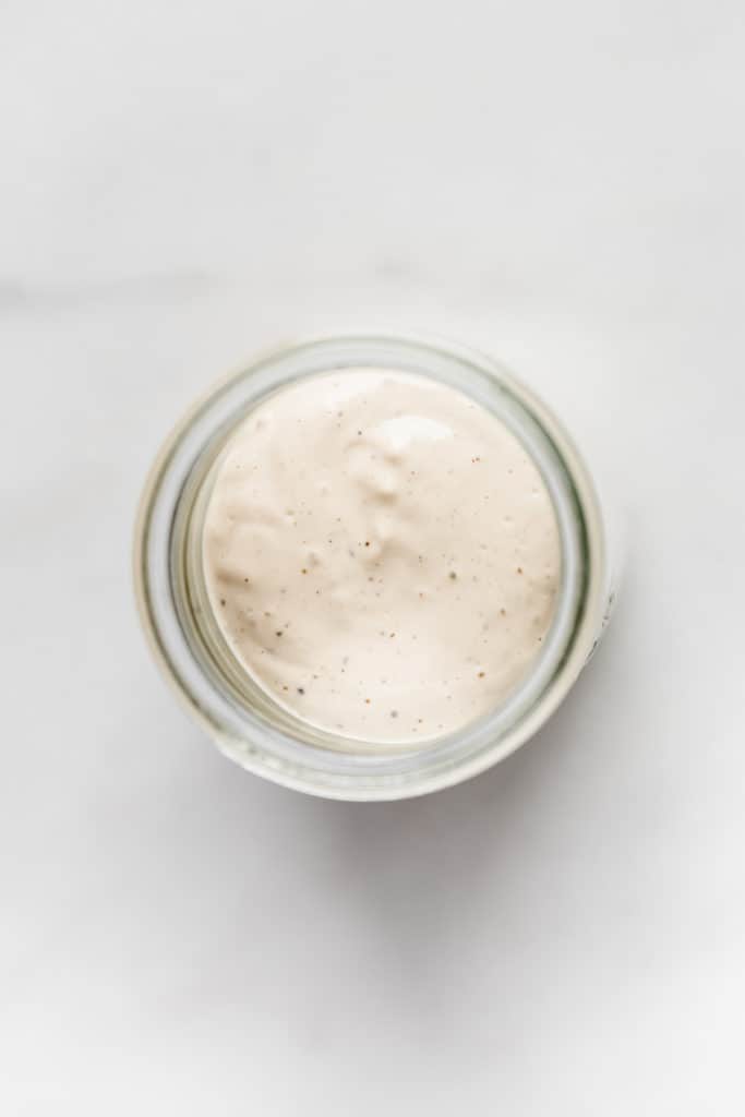 a top down view of vegan caesar salad dressing in a jar