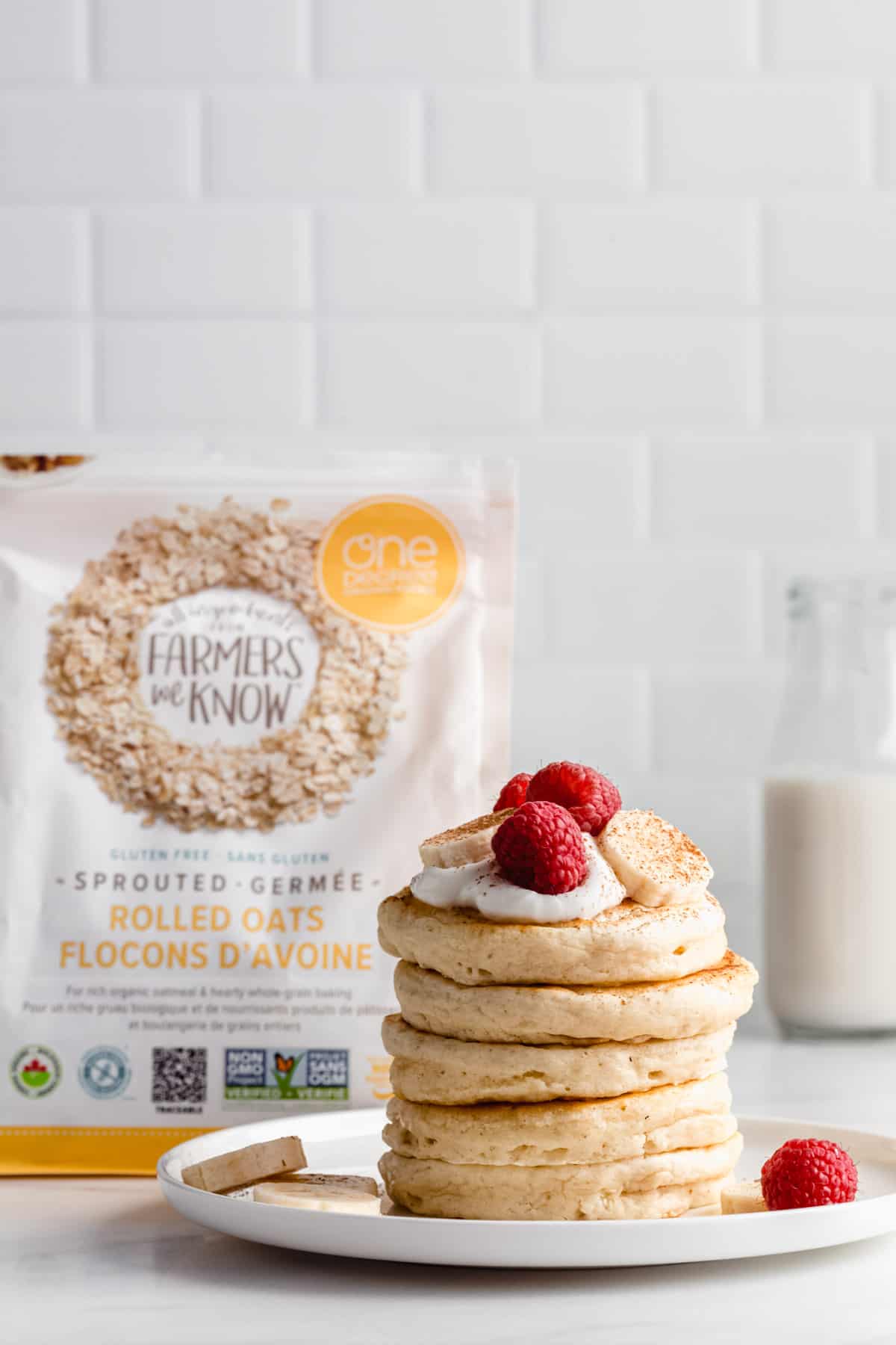 a stack of pancakes with a bag of one degree organic oats in the background