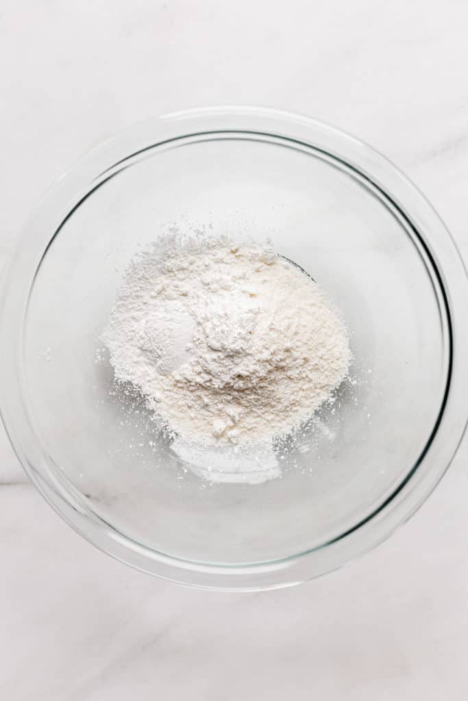 a clear mixing bowl with coconut flour in it