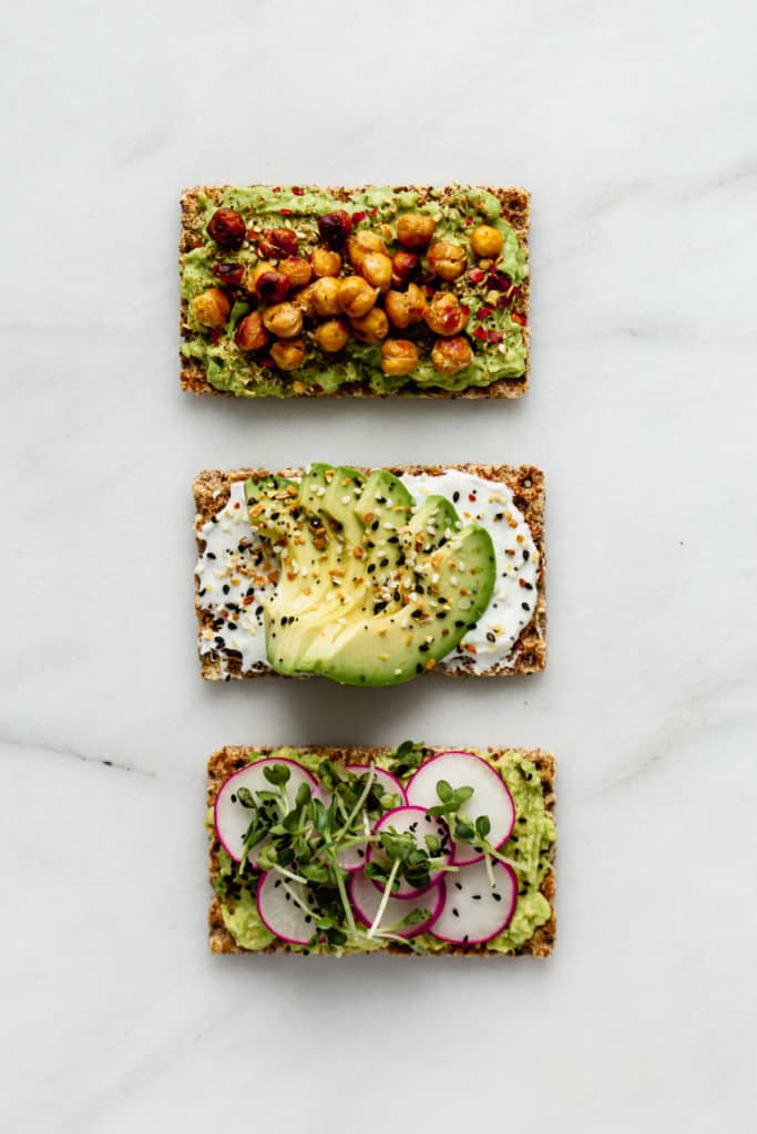 three ryvita crackers topped with avocado