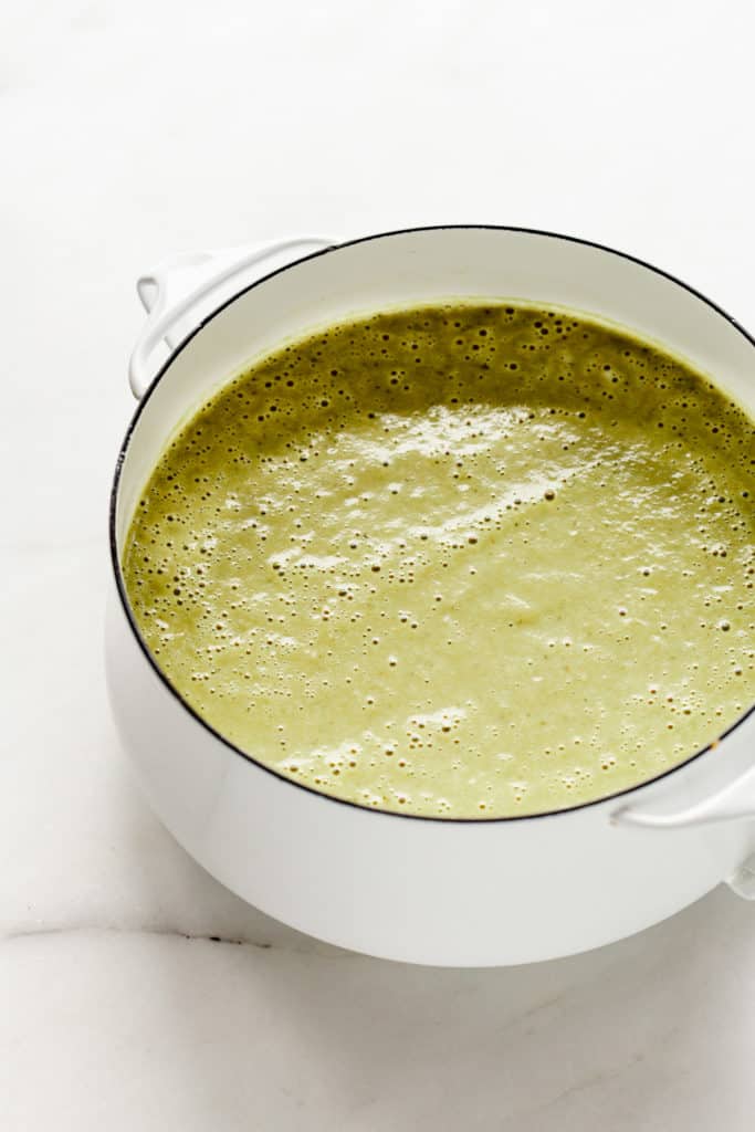A white pot with creamy vegan asparagus soup in it