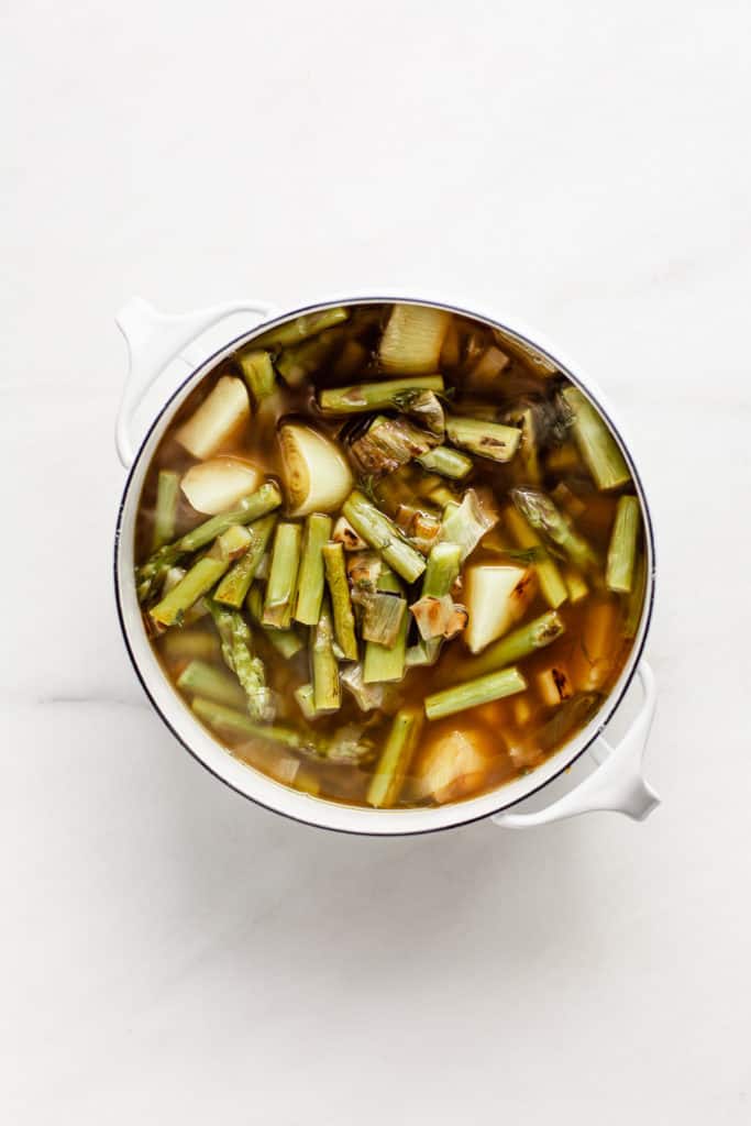 Leaks, asparagus potato and broth in a white pot