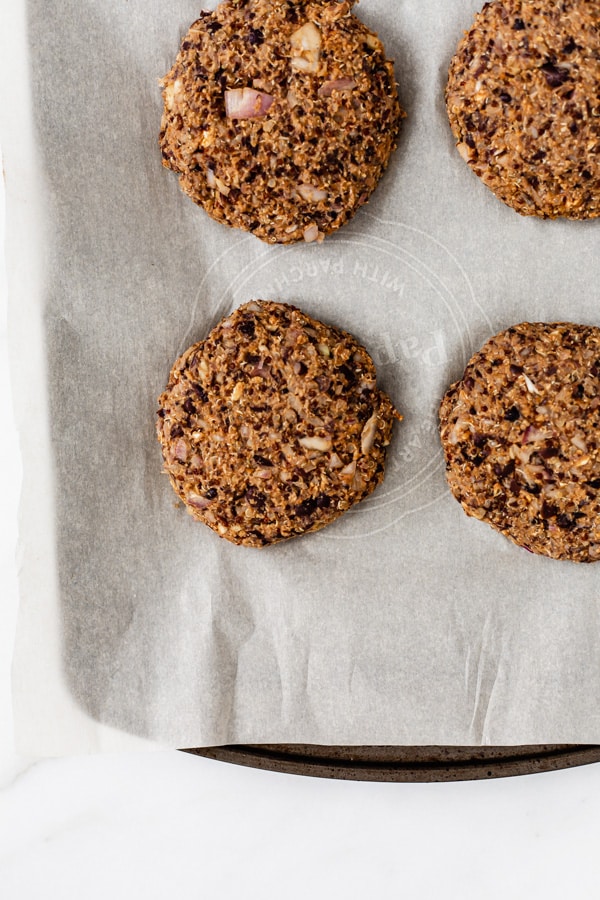 uncooked black bean and quinoa burgers on a baking pan