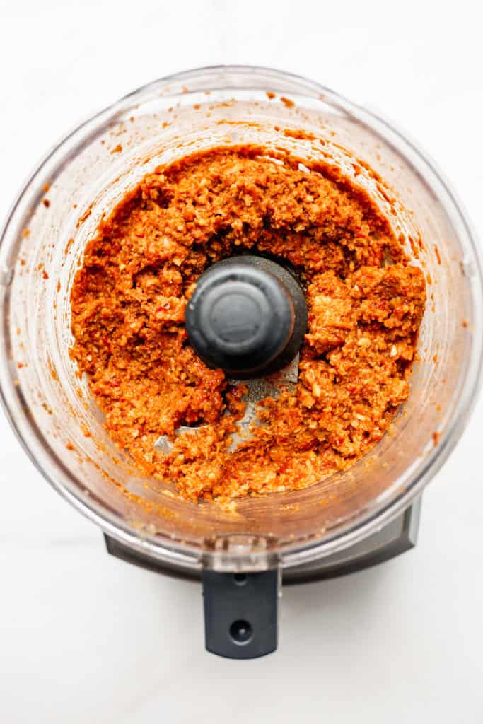 a food processor with roasted red pepper dip in it