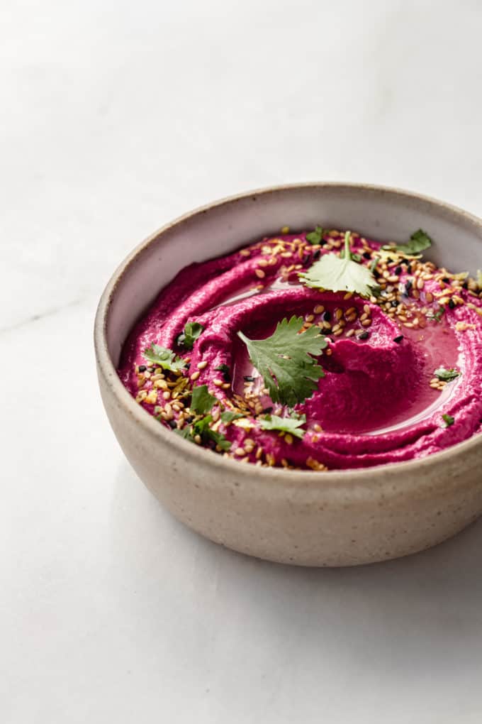 Beet hummus is a beige bowl