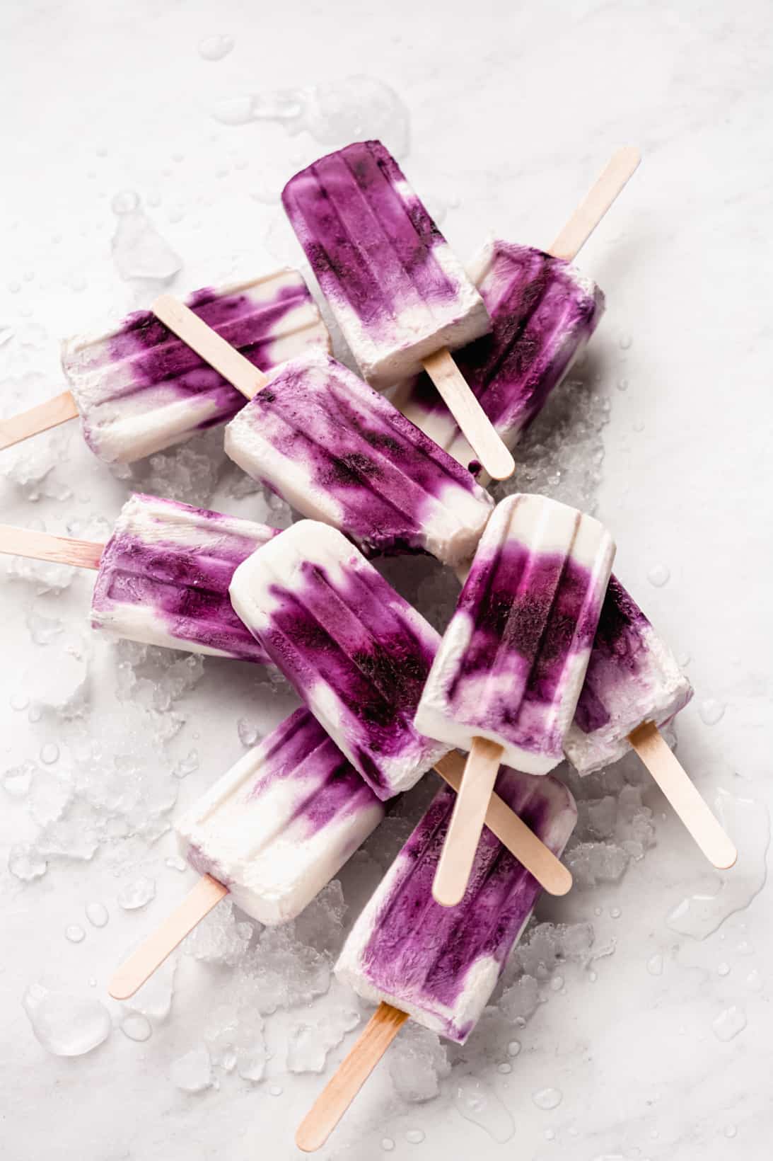 a stack of blueberry greek yogurt popsicles