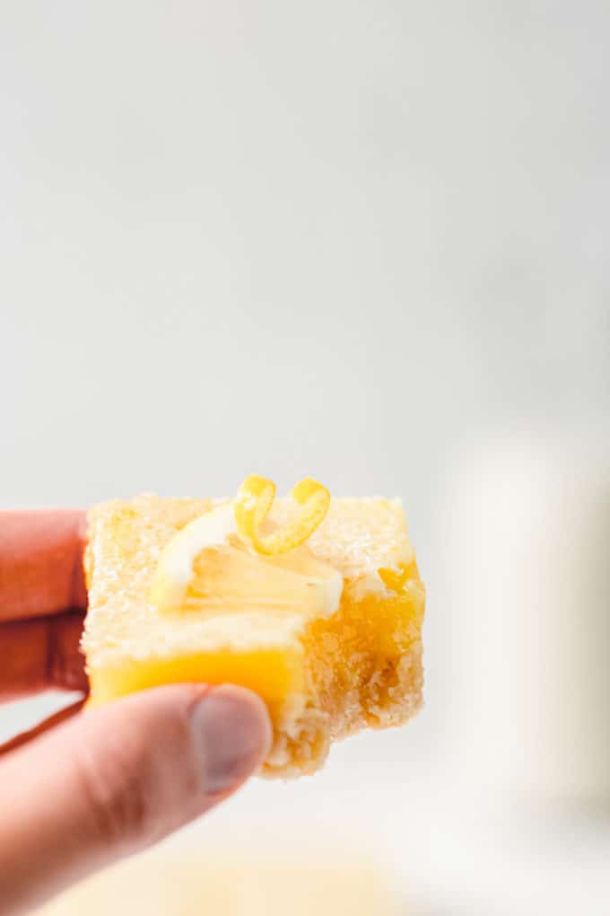 a hand holding a lemon bar