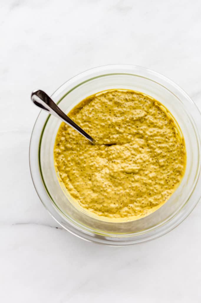 A clear mixing bowl filled with mango chia pudding
