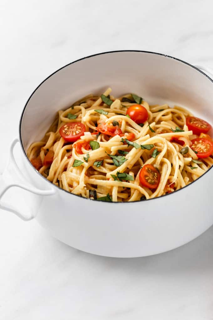 linguine with basil and cherry tomatoes in a white pot