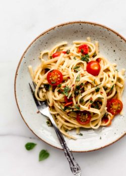 linguine pasta with cherry tomatoes on a white ceramic plate