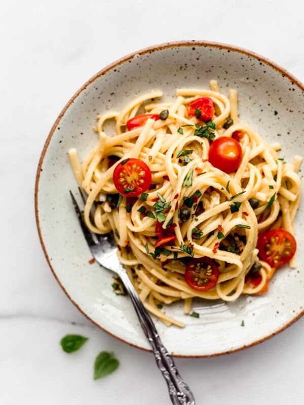 linguine pasta with cherry tomatoes on a white ceramic plate