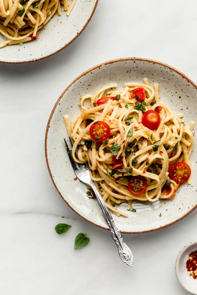 A plate with pasta and cherry tomatoes in it