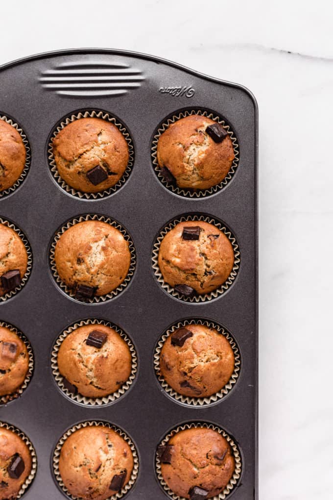 chocolate chunk banana muffins in a muffin pan