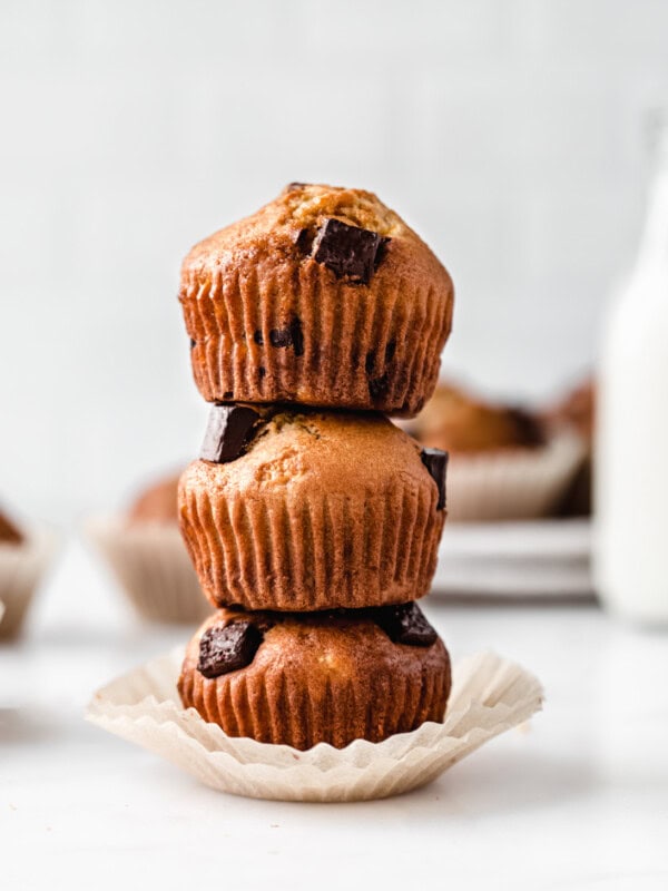 thee banana muffins with chocolate chunks stacked on top of each other
