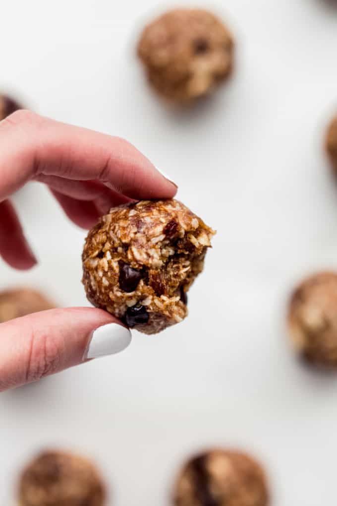 a hand holding an energy ball with a bite taken out of it
