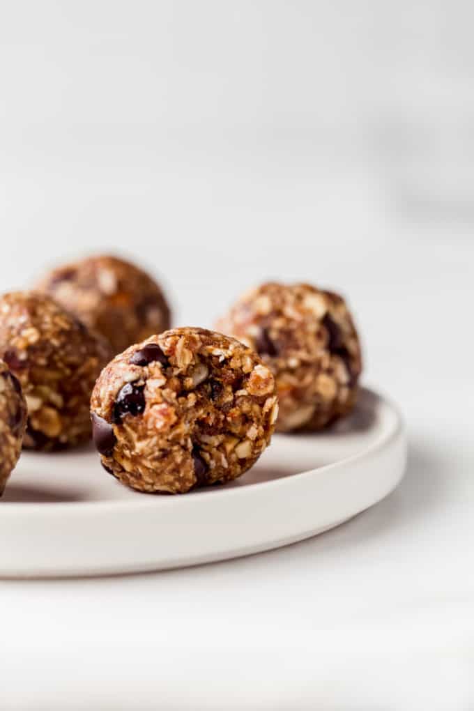 an energy ball on a white plate with a bite taken out of it