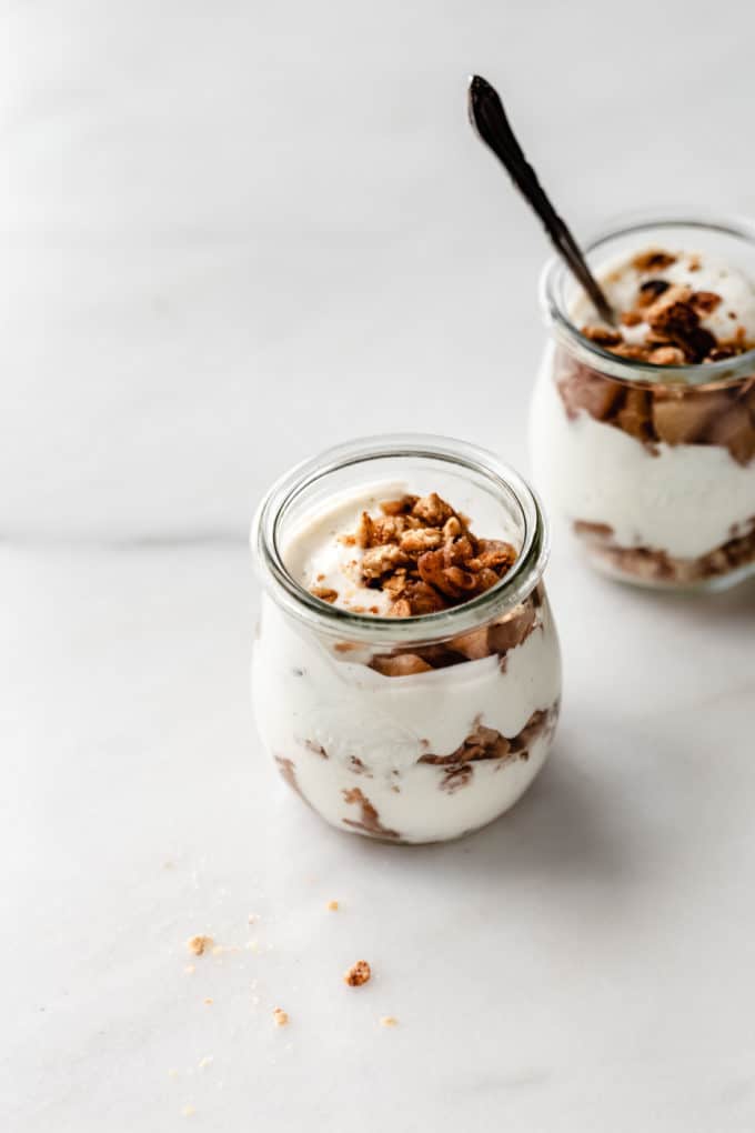 a jar of greek yogurt with apples and granola