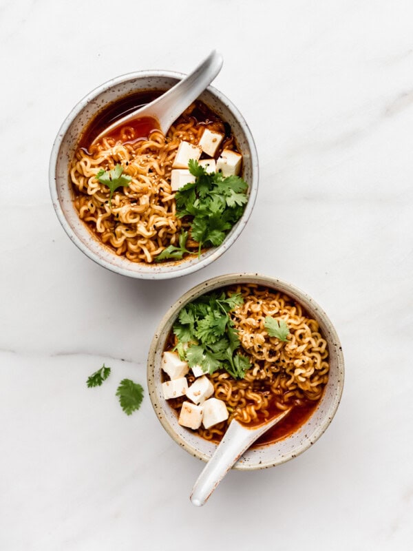 two bowls of ramen with noodles, tofu and cilantro