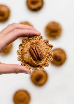 a hand holding up a mini pecan pie