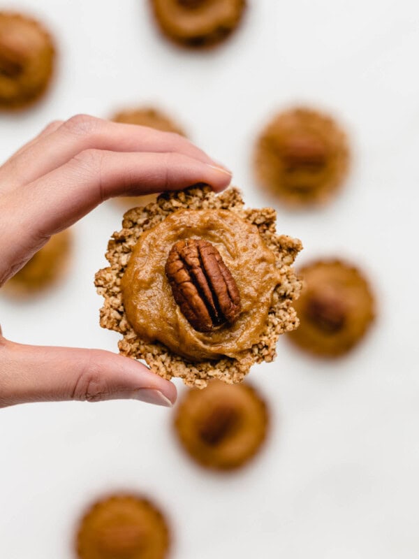 a hand holding up a mini pecan pie