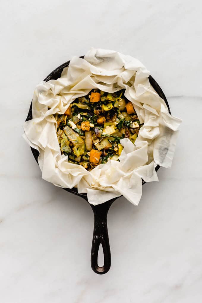 an unbaked veggie phyllo pie in a cast iron skillet