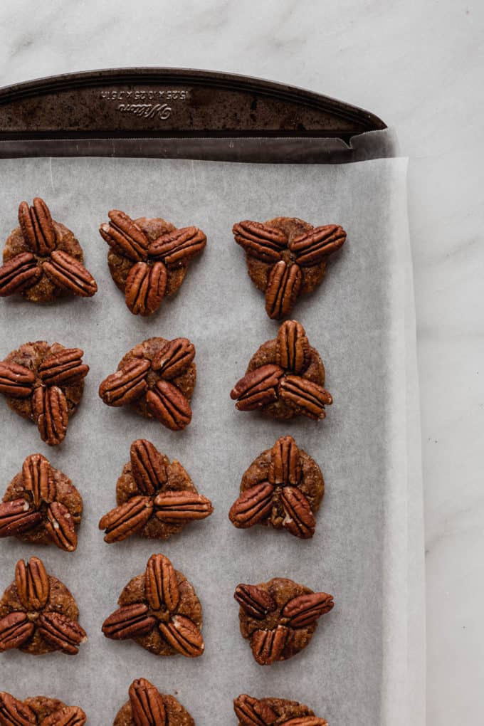 A baking sheet with date and pecan patties on it