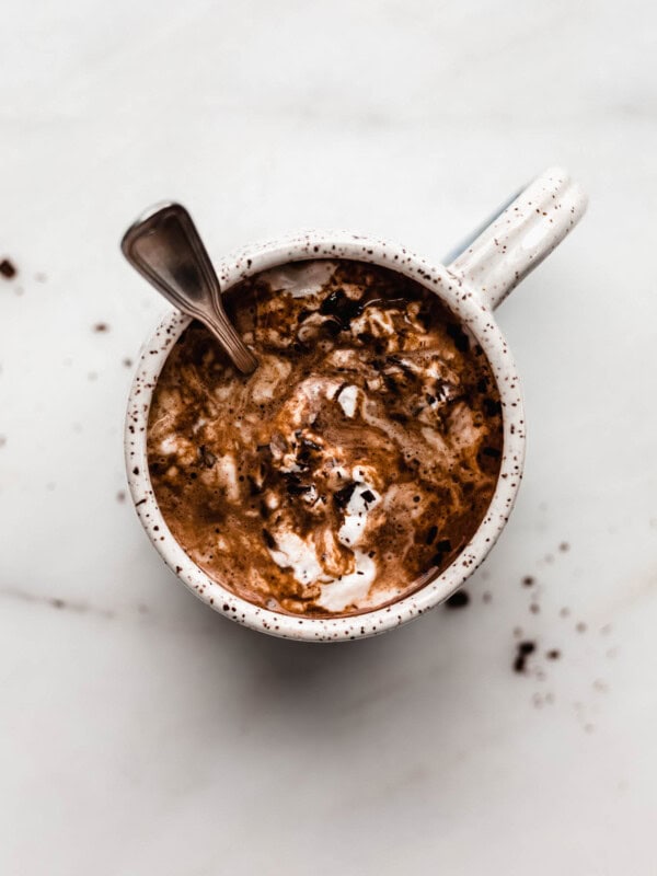A mug of hot chocolate with a spoon in it