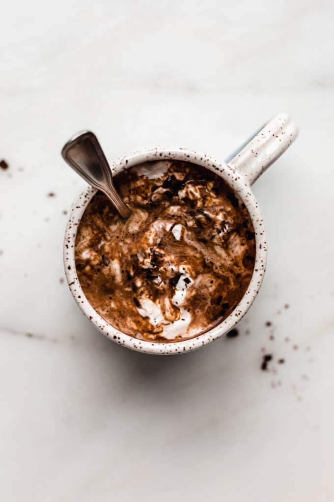 A mug of hot chocolate with a spoon in it