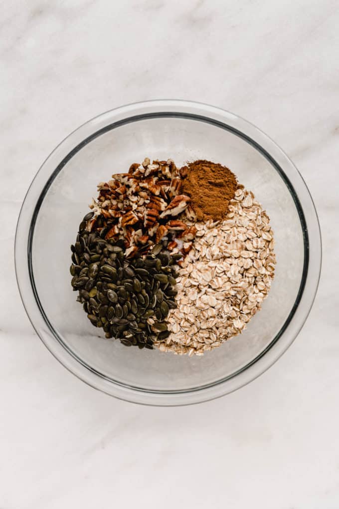 A mixing bowl of oats, pumpkin seeds and pecans