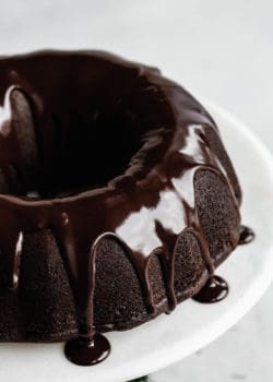 A close up of a gingerbread bundt cake with chocolate glaze dripping down the sides