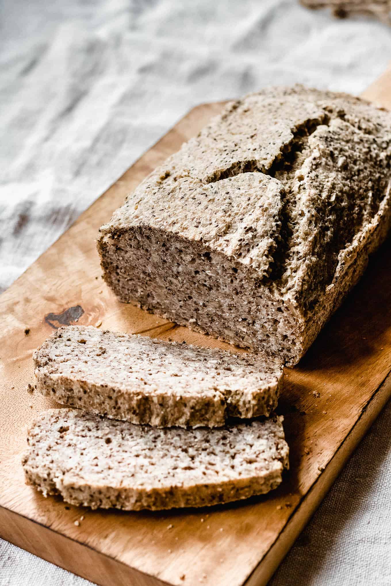 a loaf of buckwheat and chia seed bread on a bread board