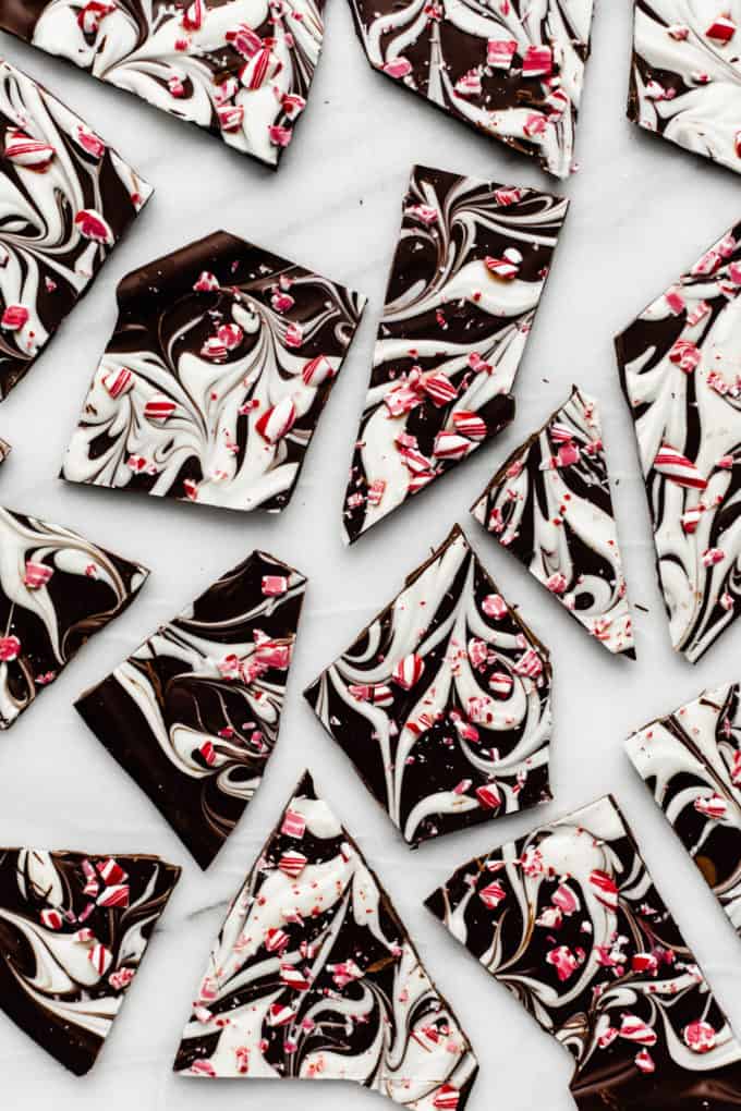 peppermint bark broken up on a marble tray with crushed candy canes on top